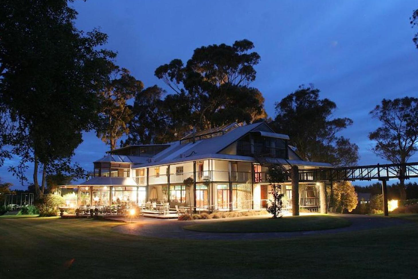 A large Hamilton B&B is aglow with light against the evening sky.